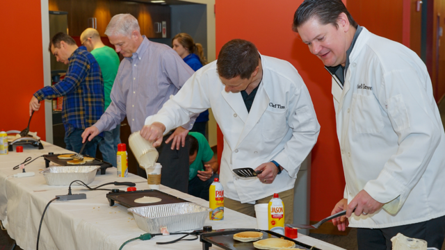 Ash Brokerage Leadership Cooking Pancakes For Fundraiser